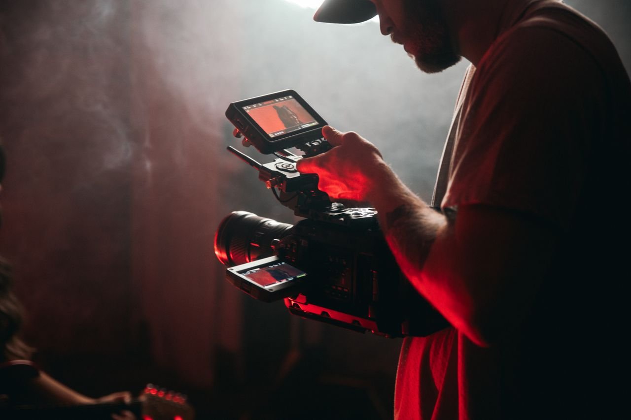 A cinematographer filming on set using professional camera gear, capturing a cinematic scene.